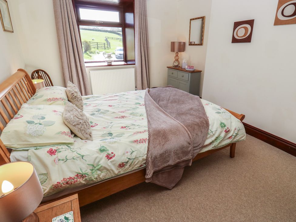 A bedroom with a bed and a window at Shoebroad Barn in Todmorden