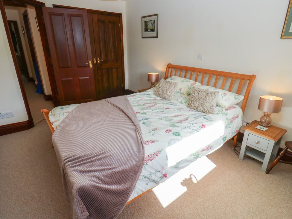 A bedroom with a bed and two bedside lamps at Shoebroad Barn Todmorden
