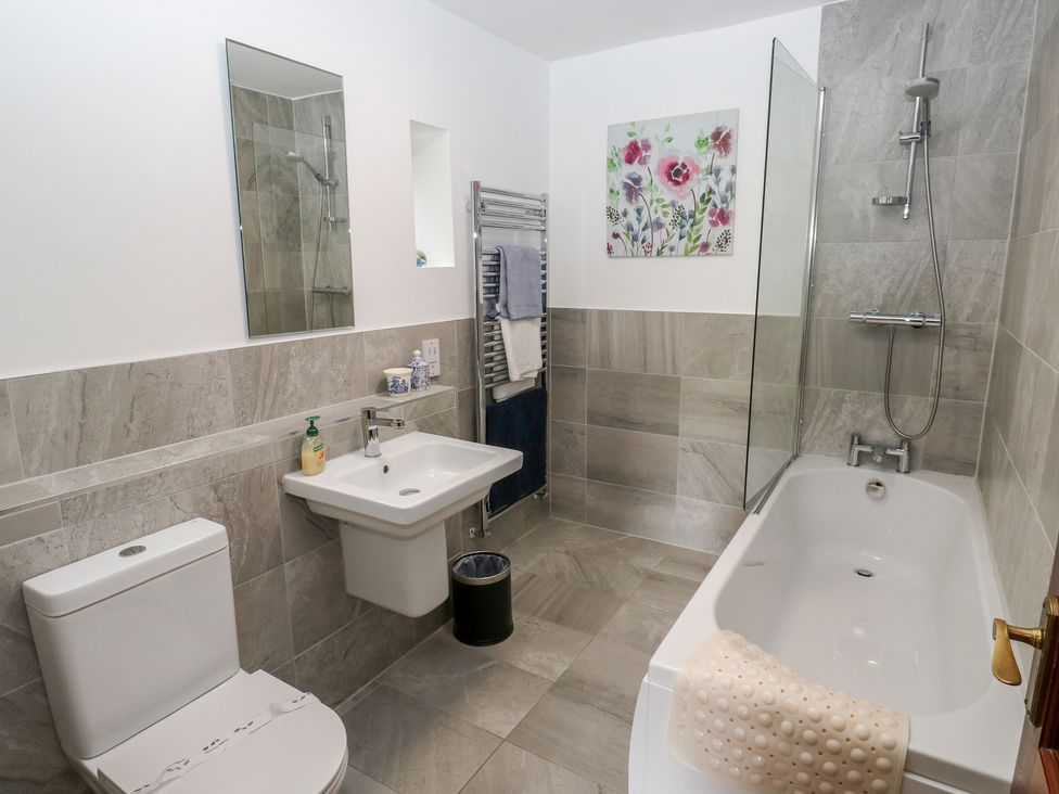 A bathroom with a bathtub, toilet, and sink at Shoebroad Barn Todmorden