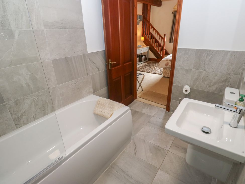 A bathroom with a bathtub and a washbasin at Shoebroad Barn Todmorden