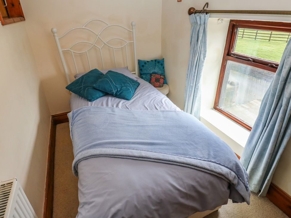 A bedroom with a bed and window at Shoebroad Barn Todmorden