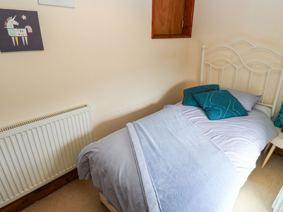 A bedroom with a bed and wall art at Shoebroad Barn in Todmorden