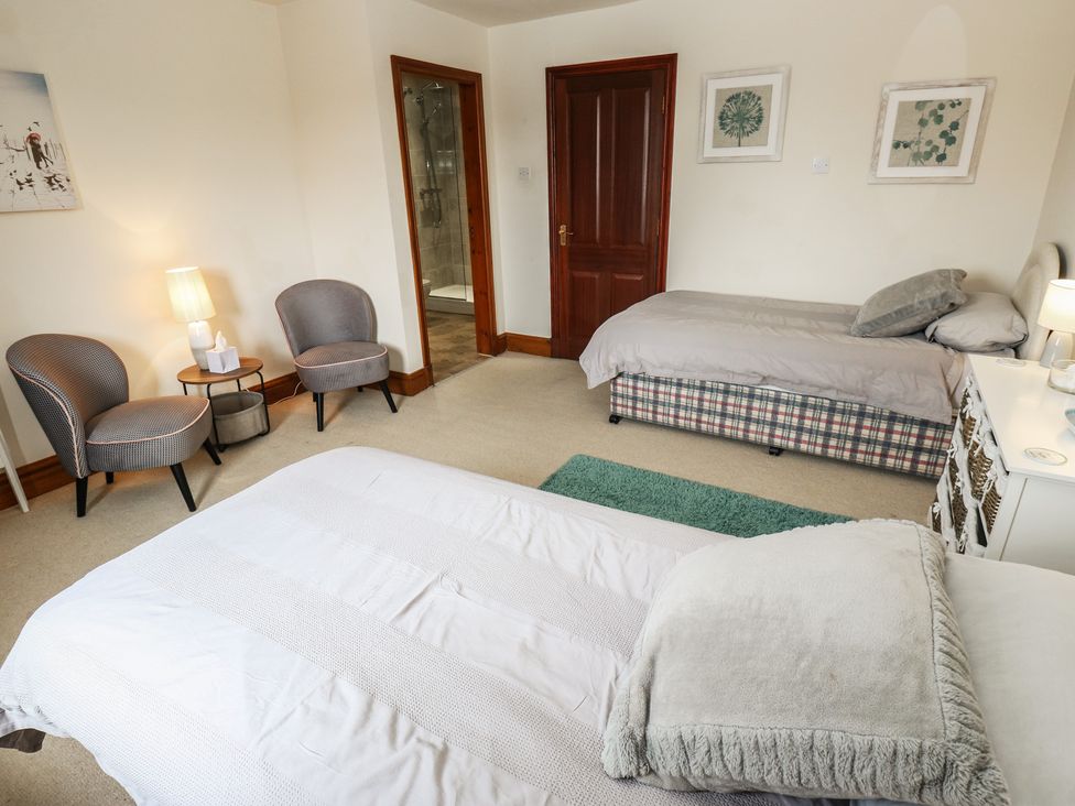 A bedroom with two beds and chairs at Shoebroad Barn in Todmorden