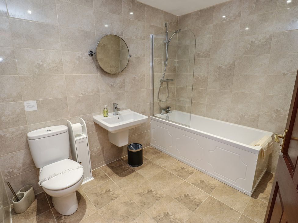 A bathroom with a bathtub, sink, and toilet at Shoebroad Barn in Todmorden