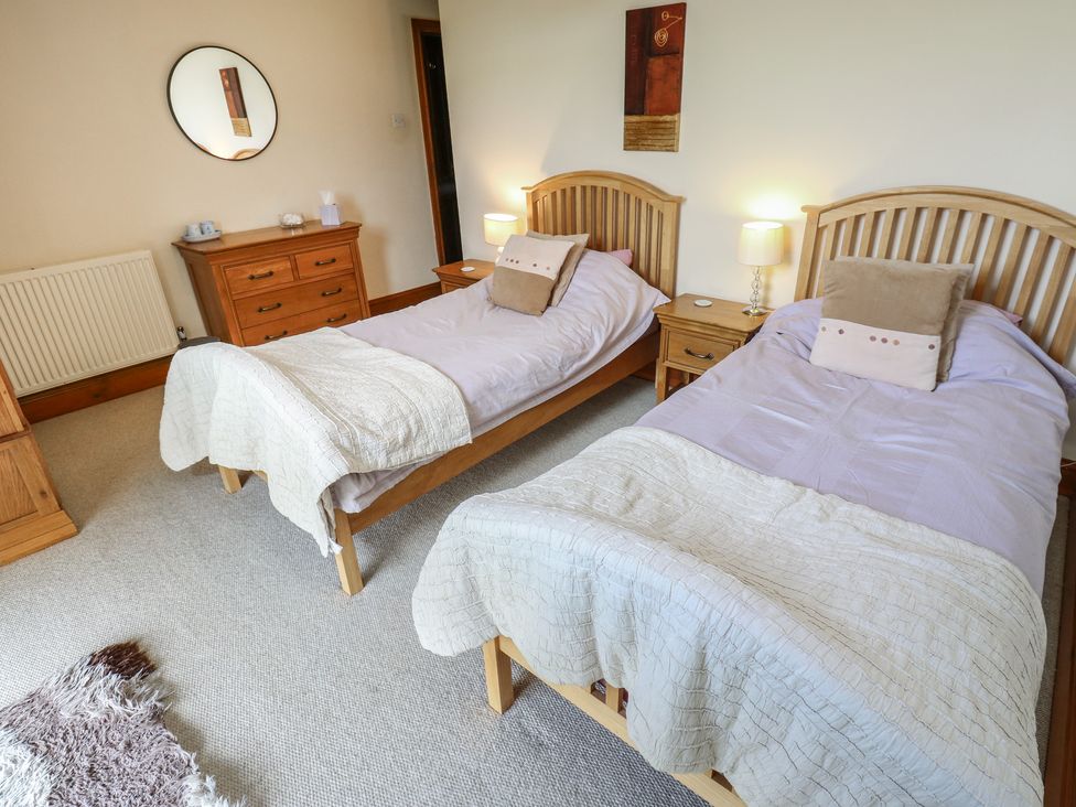 A bedroom with two beds and furniture at Shoebroad Barn in Todmorden