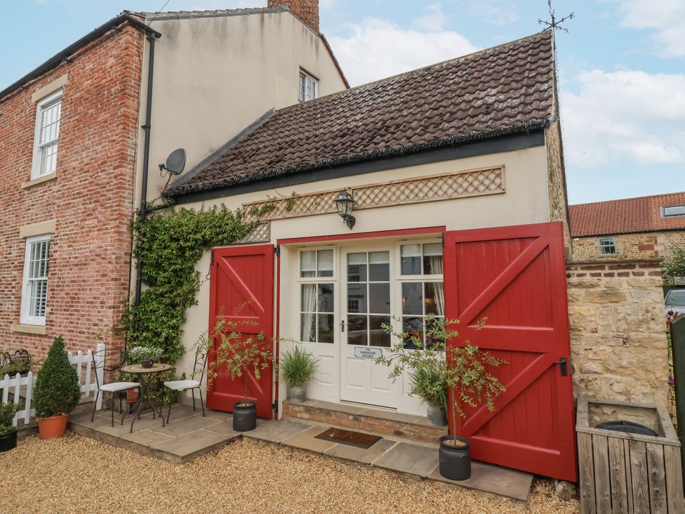 An outdoor area with a building entrance and seating at The Farmhouse Kitchen in Ripon