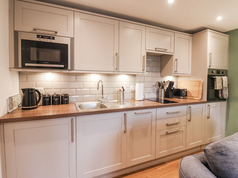 A kitchen with cabinets, sink, microwave, and kitchen appliances at The Farmhouse Kitchen in Ripon