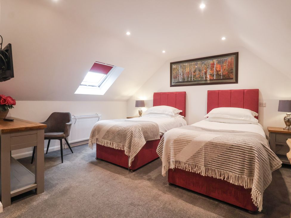 A bedroom with two beds and a television at The Farmhouse Kitchen in Ripon