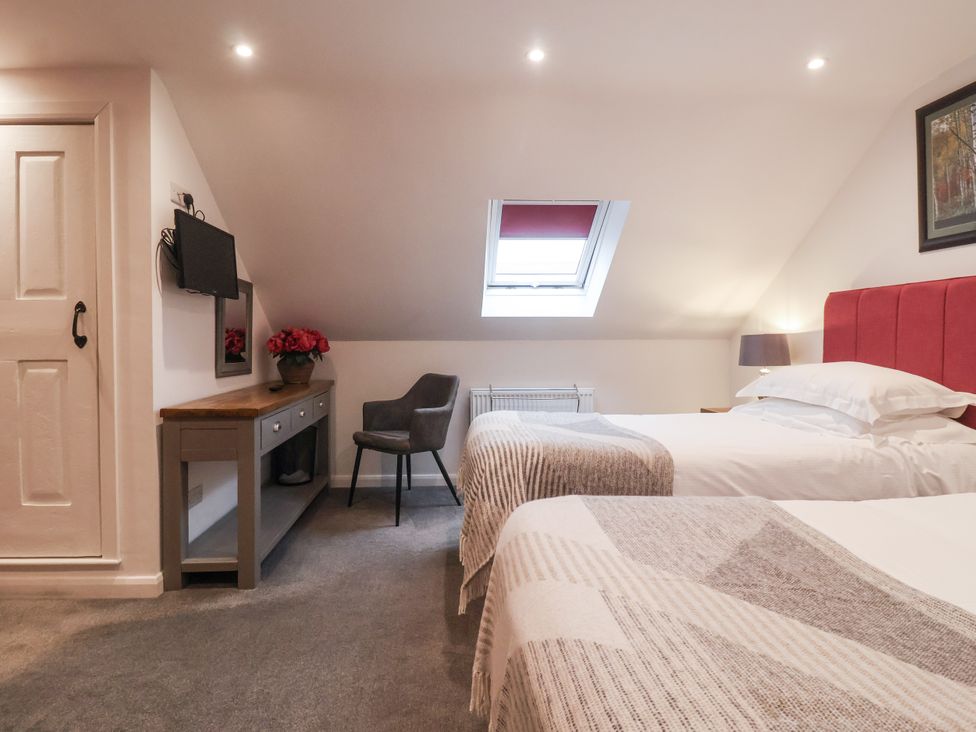 A bedroom with two beds and a television at The Farmhouse Kitchen in Ripon