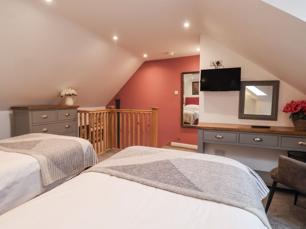 A bedroom with two beds and a television at The Farmhouse Kitchen in Ripon