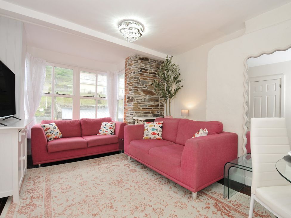 A living room with a sofa and television at Stargazy in Trebarwith Strand near Tintagel