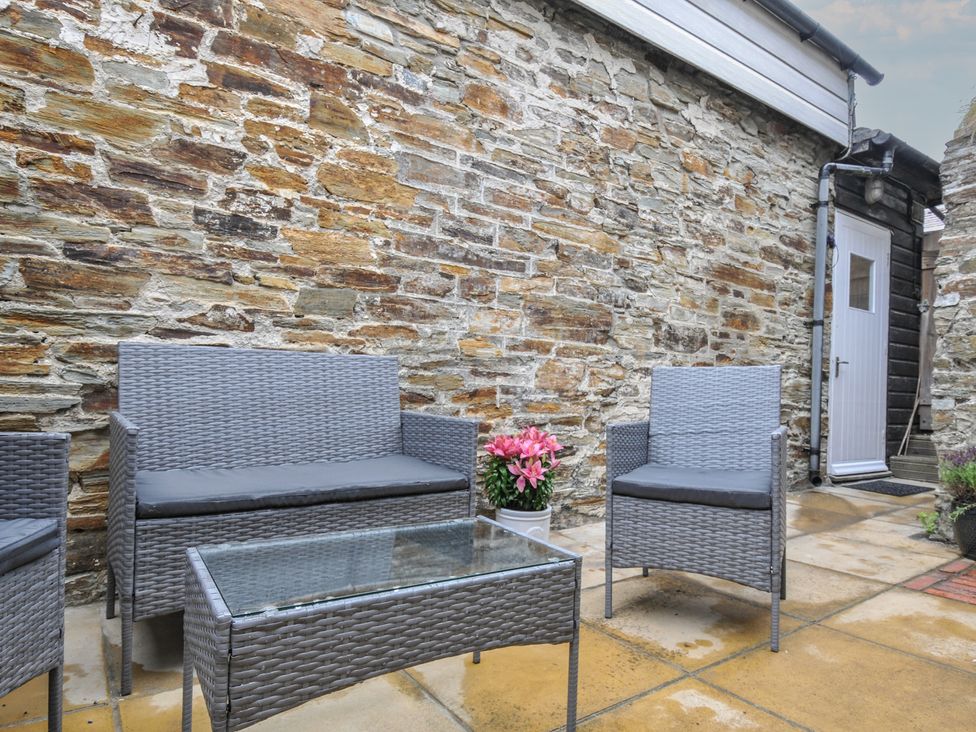 An outdoor seating area with a table and chairs at Stargazy in Trebarwith Strand near Tintagel