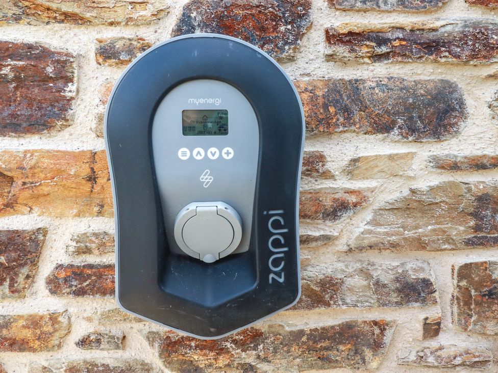 An electric vehicle charger mounted on a stone wall at Idlewild, 2 Wheal Turnavore St Agnes