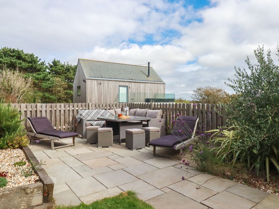 An outdoor seating area with chairs and table at Idlewild, 2 Wheal Turnavore, St Agnes