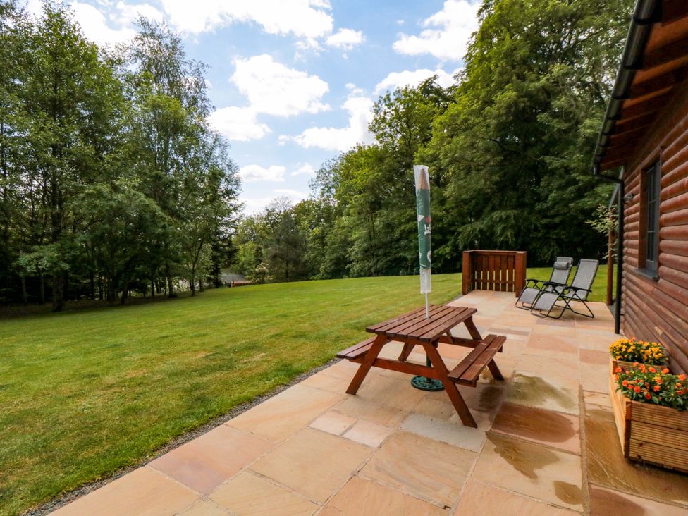 A garden with a table, chairs and a flower box at Ryedale Country Lodges - Hazel Lodge Kirkbymoorside