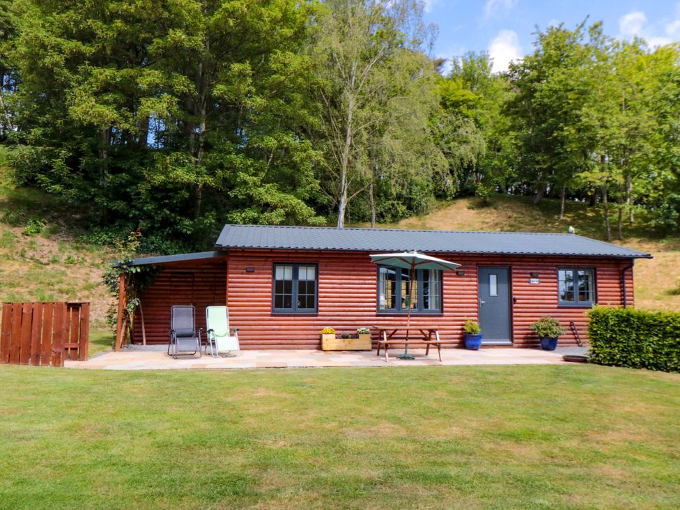A log cabin with a patio and outdoor seating at Ryedale Country Lodges - Willow Lodge in Kirkbymoorside