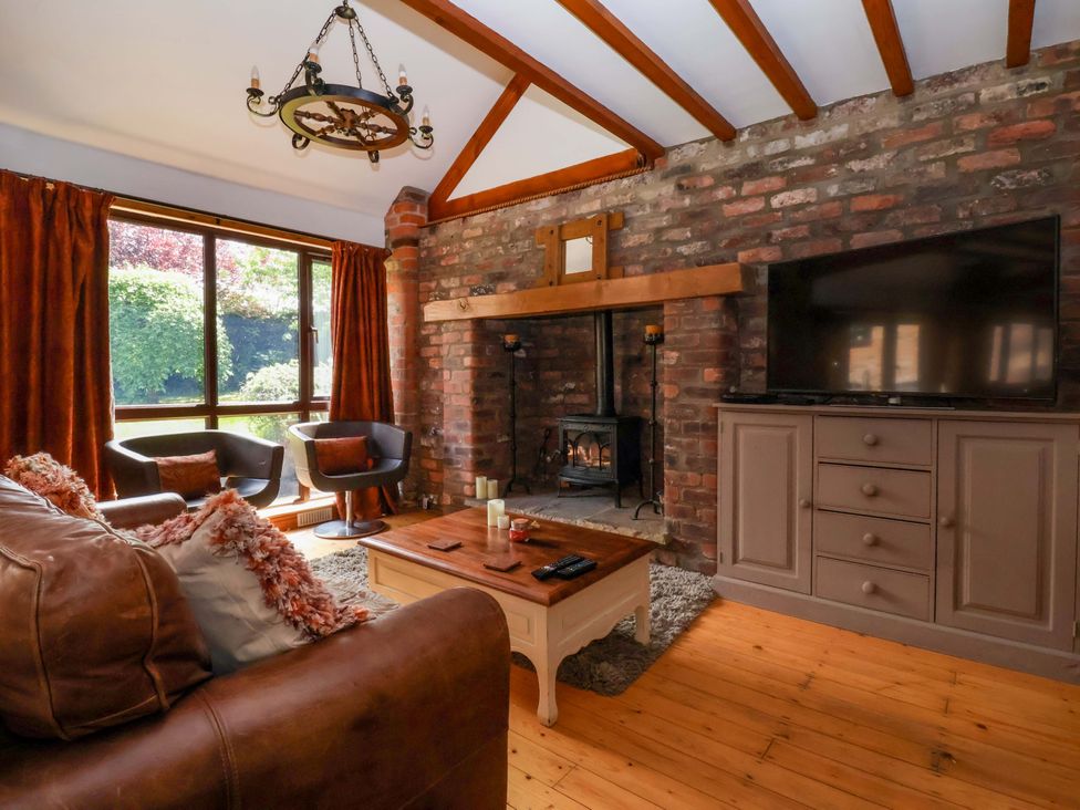 A living room with a fireplace and television at The Stables (2 bed) in Driffield