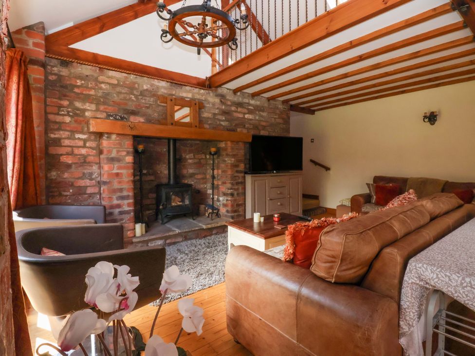 A living room with a fireplace and television at The Stables (2 bed) Driffield