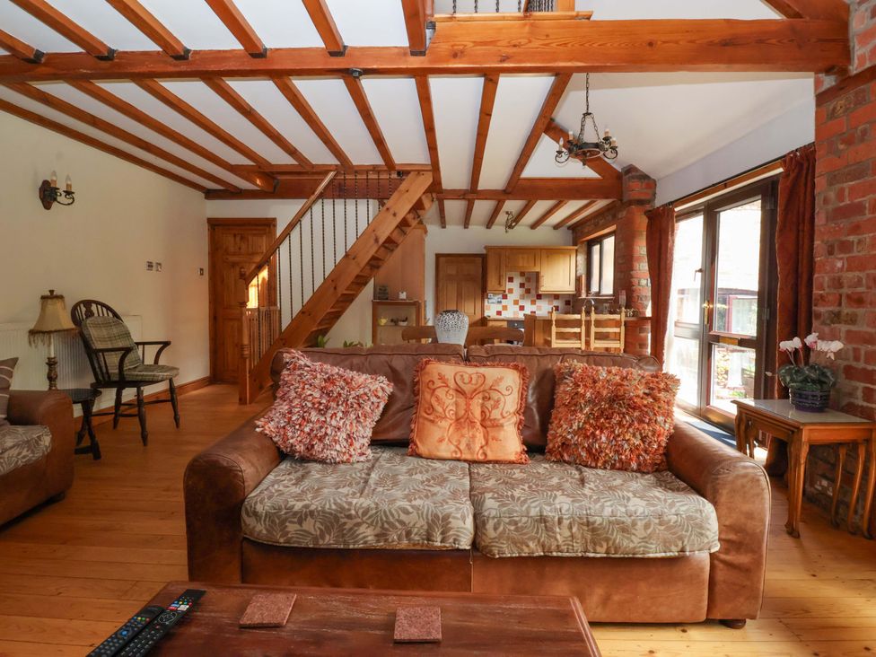 A living room featuring a sofa, armchair, and coffee table at The Stables (2 bed) Driffield