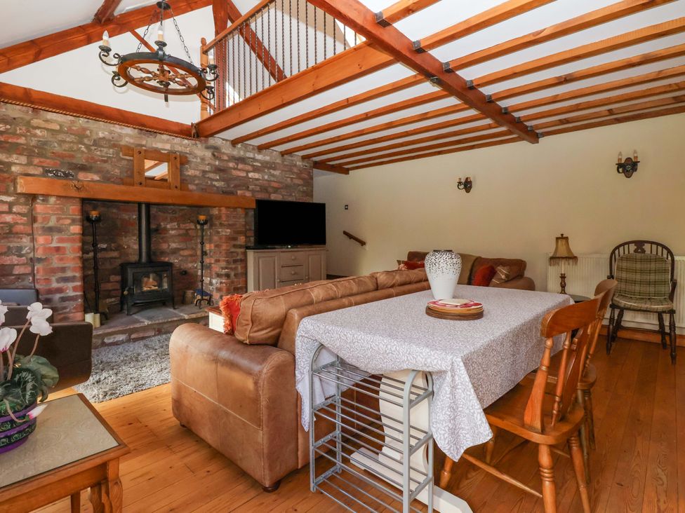 A living room with a fireplace and seating area at The Stables (2 bed) Driffield