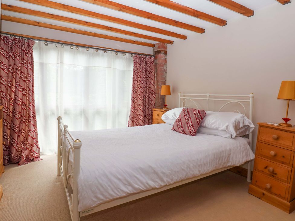 A bedroom with a bed and nightstands at The Stables (2 bed) Driffield