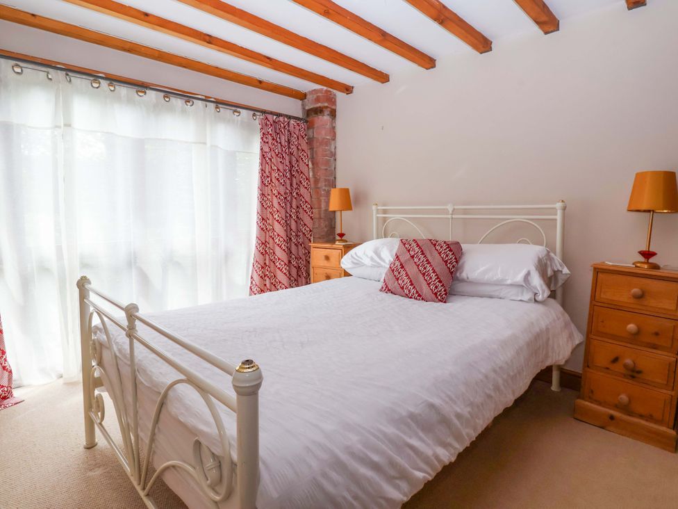 A bedroom with a bed and bedside tables at The Stables (2 bed) Driffield