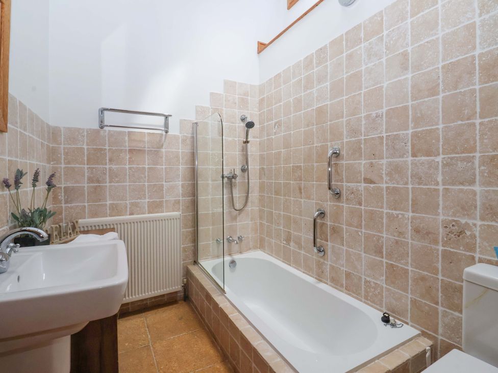 A bathroom with a bathtub and sink at The Stables (2 bed) Driffield