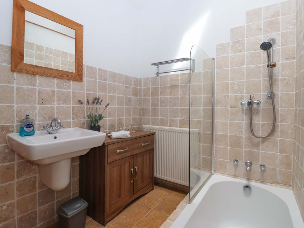 A bathroom with a sink, shower, tub, and cabinet at The Stables (2 bed) in Driffield
