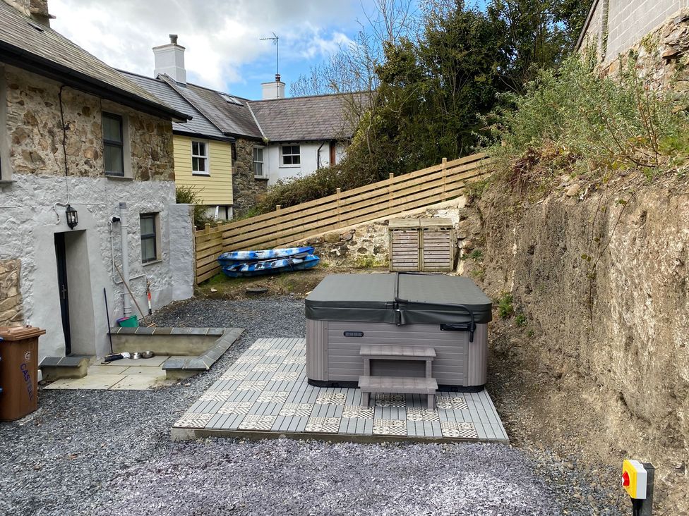A hot tub and paved area with gravel at The Cottage in Llaniestyn