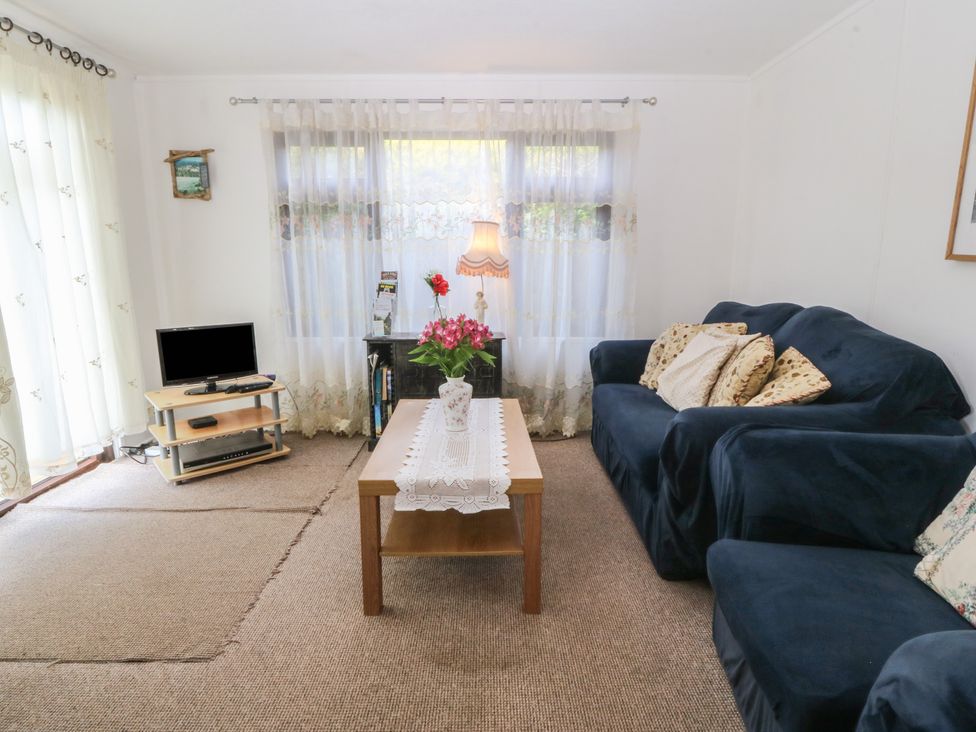 A living room with a sofa and coffee table at Castell Chalet Penrhos near Pwllheli