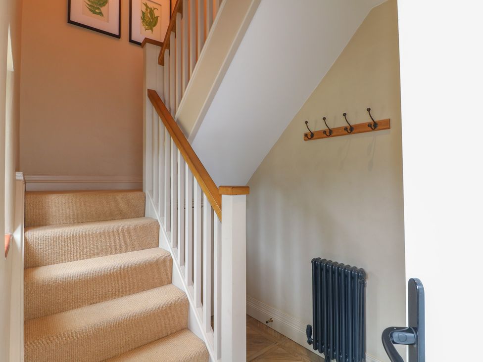 A staircase with wall hooks and a radiator at Ivet Lowe Hopton near Wirksworth