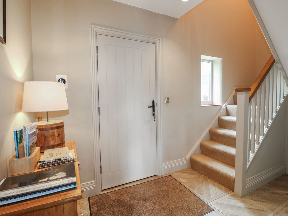 A hallway with a door and staircase at Ivet Lowe in Hopton near Wirksworth