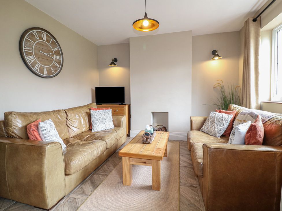 A living room with a sofa, table, and television at Ivet Lowe Hopton near Wirksworth