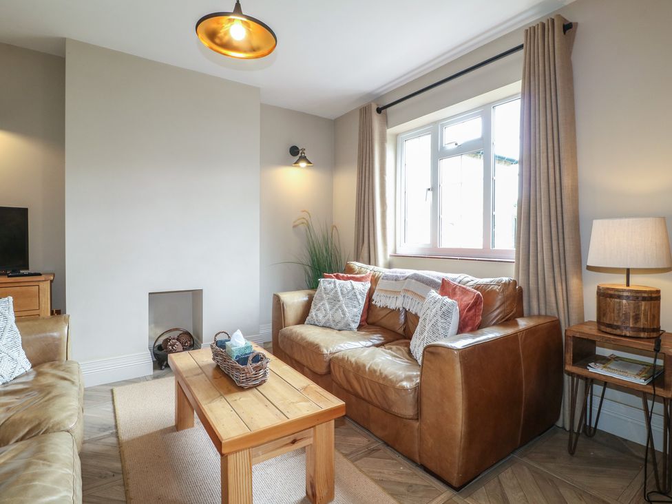 A living room with a sofa and coffee table at Ivet Lowe in Hopton near Wirksworth