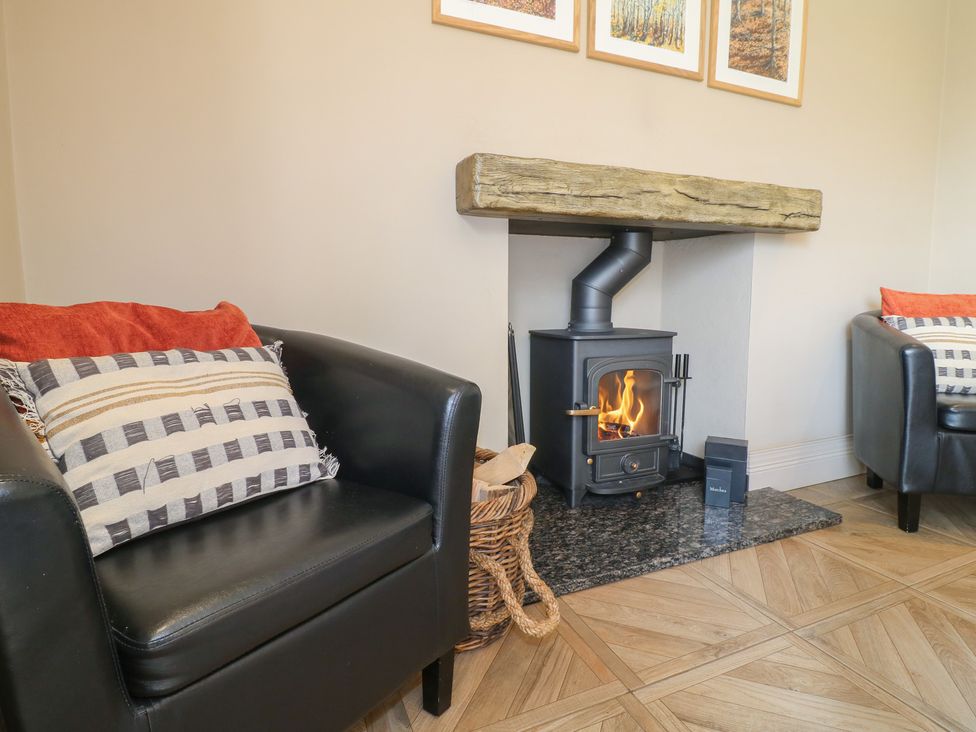 A living room with an armchair and a fireplace at Ivet Lowe in Hopton near Wirksworth