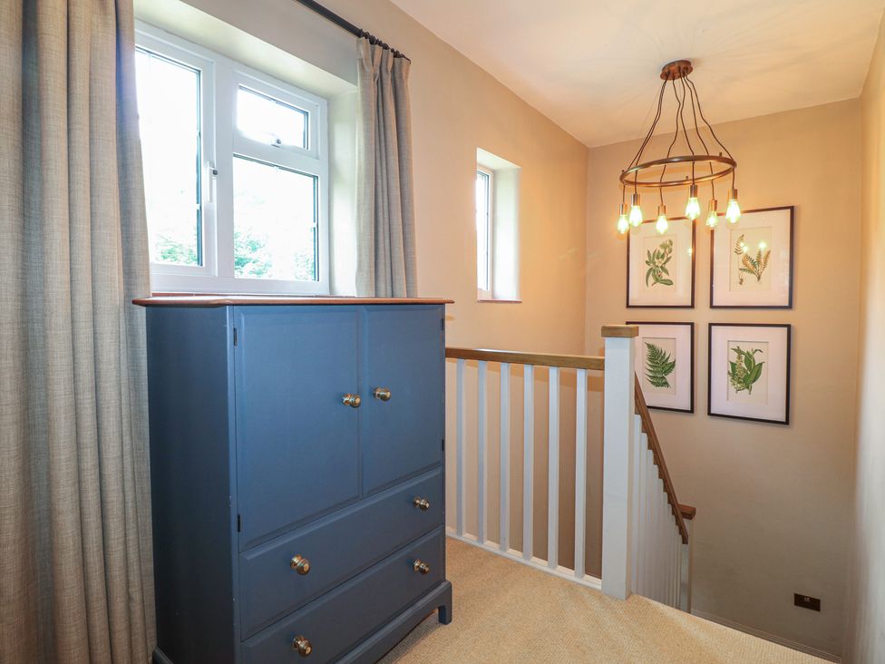 A hallway with a chest of drawers and framed artwork at Ivet Lowe Hopton near Wirksworth