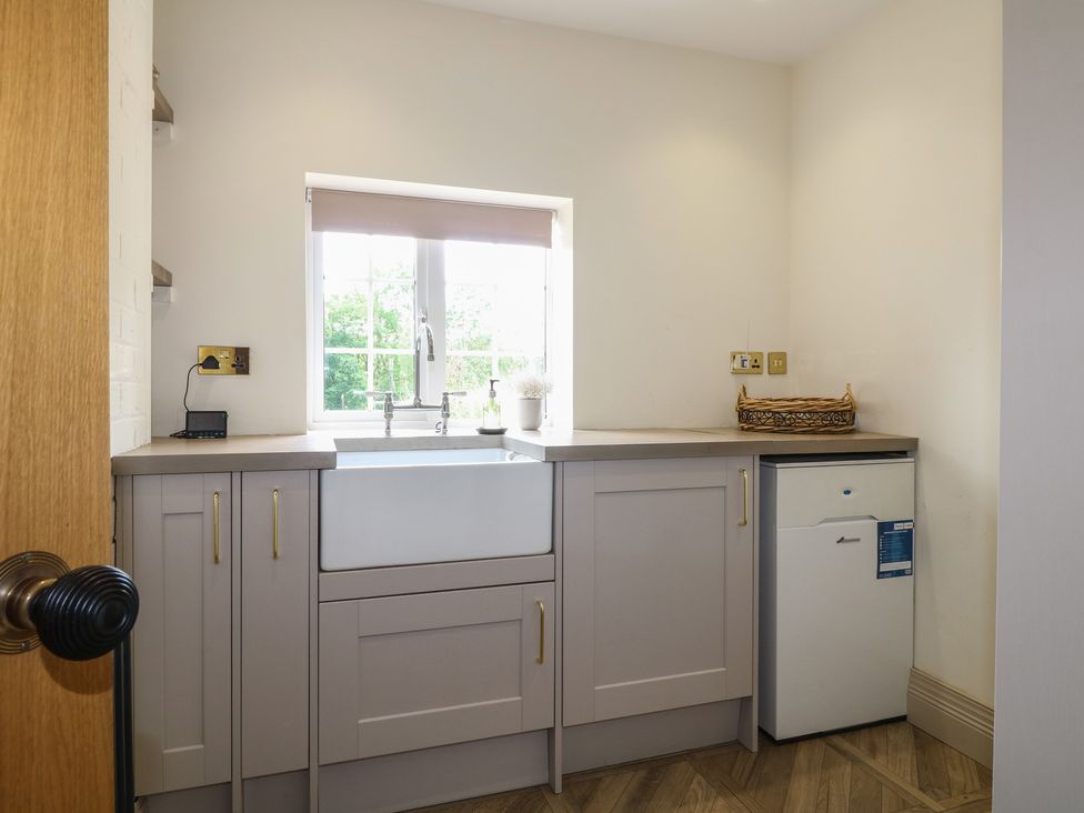 A kitchen with a sink, cabinets, and a refrigerator at Ivet Lowe in Hopton near Wirksworth
