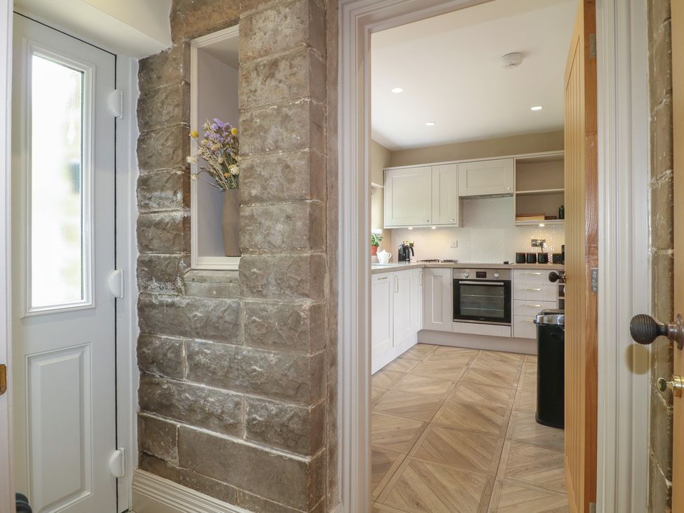 A view into a kitchen with cabinets and a door at Ivet Lowe in Hopton near Wirksworth