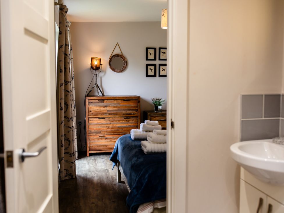 A bedroom with a chest of drawers and towels at Betony in Bamburgh