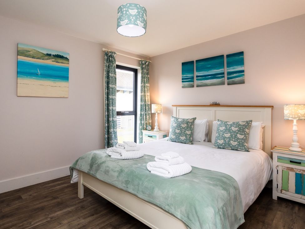 A bedroom with a double bed and wall art at Betony in Bamburgh