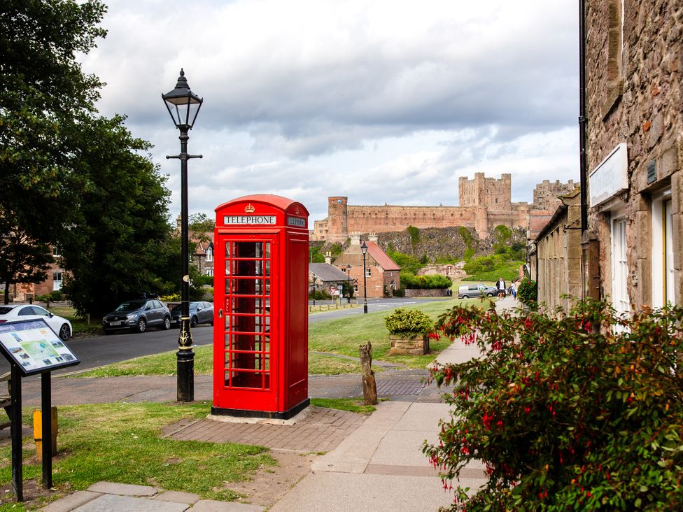 A street view with a telephone booth and a castle in the background at Betony in Bamburgh