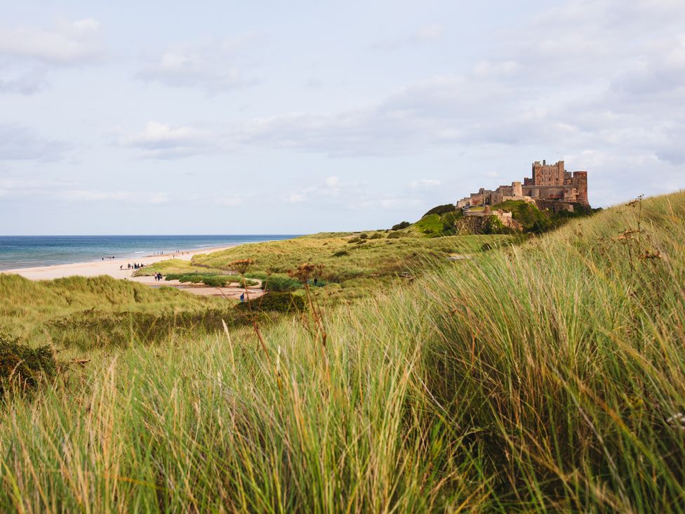 A beach with a castle in the background at Betony in Bamburgh