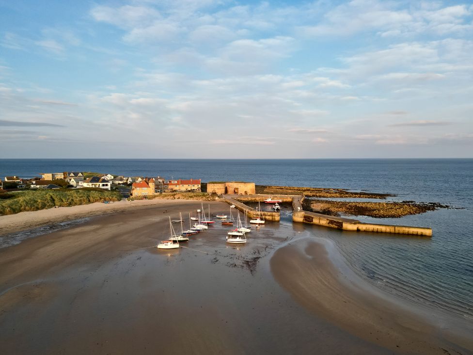 A view of boats at a pier along the beach at Betony in Bamburgh