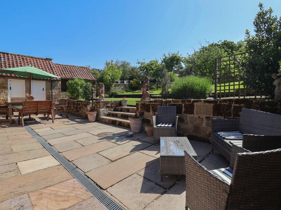 A garden with patio furniture and landscaping at Webstone House in Thimbleby near Osmotherley