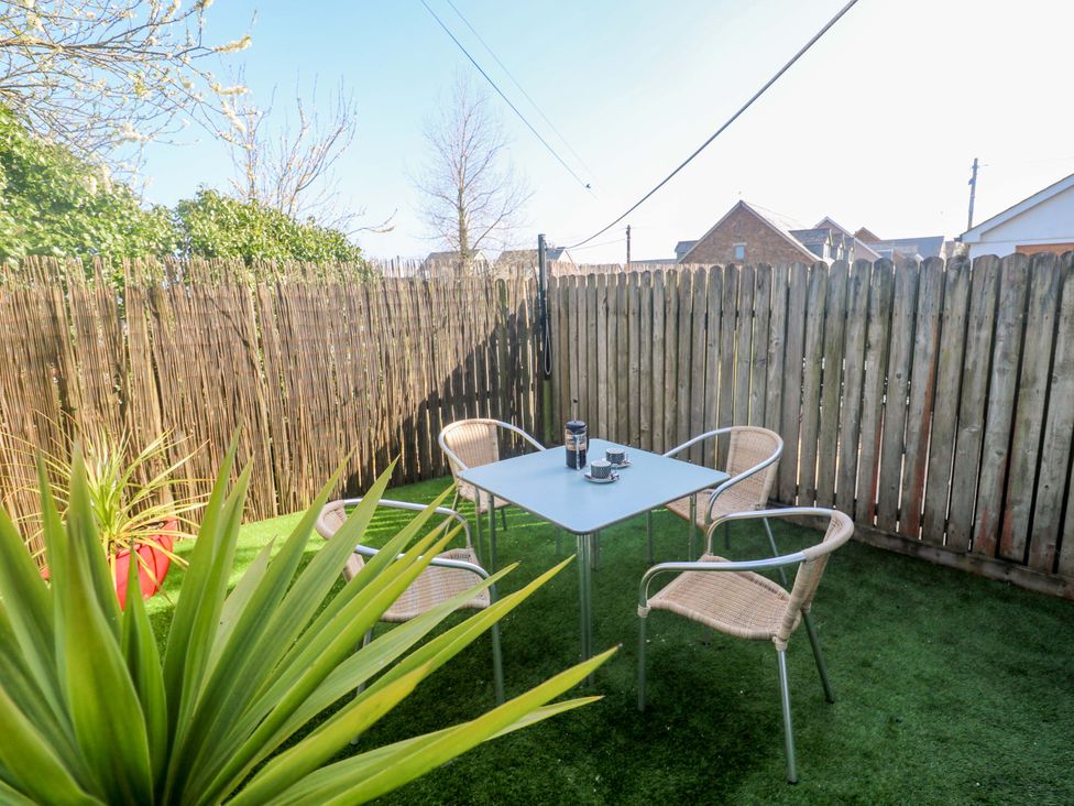 A garden with a table and chairs at Sunflower Cottage in St Issey