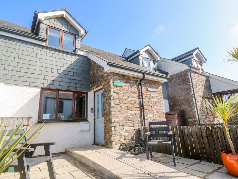 An outdoor area with a chair and plants at Sunflower Cottage in St Issey