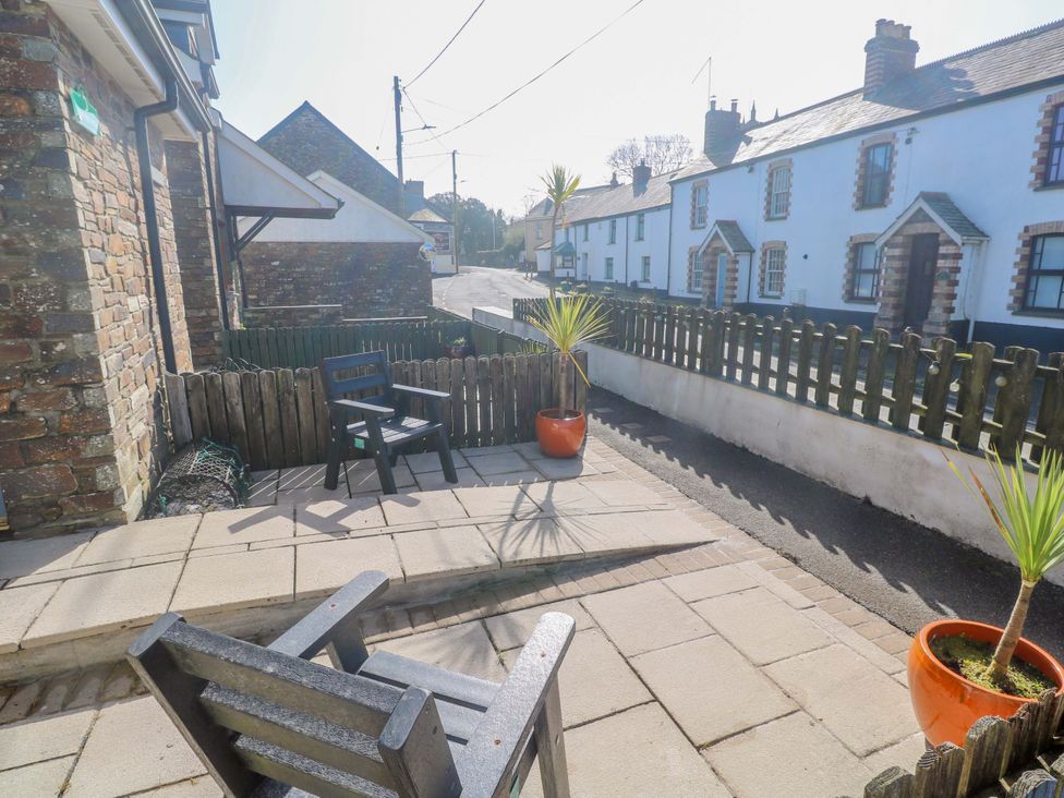 A patio area with outdoor chair and planters at Sunflower Cottage in St Issey