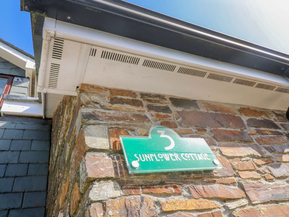 Building sign on a stone wall at Sunflower Cottage St Issey