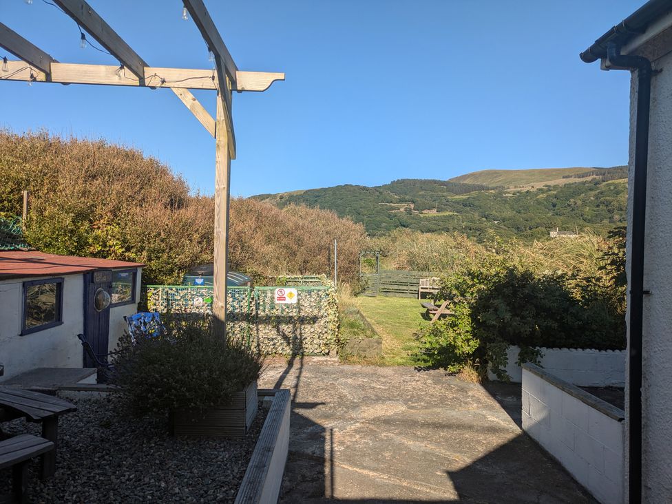 A garden with a bench and gravel pathway at Minydon in Fairbourne