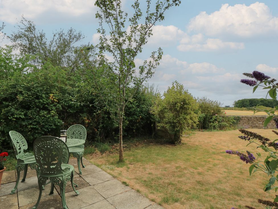 A garden with chairs and a table at The Lodge at Mortons in Hankerton